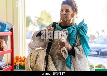 Eine Frau, die Obst in einem Gemüsehändler kauft Stockfoto