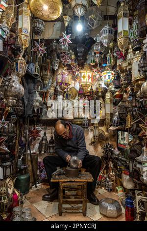 Handwerker, die Metalllampen in einem Geschäft in der Medina von Marrakesch herstellen. Stockfoto