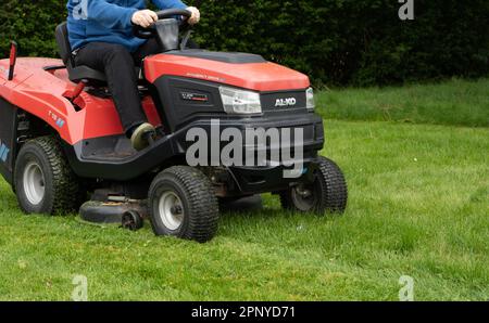 Ein Mann mäht Gras mit einem ALKO Ride on Rasenmäher. Stockfoto