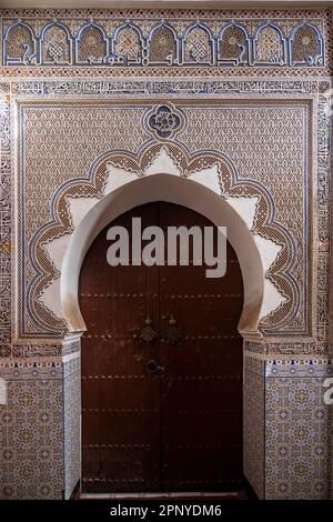 Eingangstür zu einer kleinen Moschee mit arabischen Ornamenten in der Medina von Marrakesch. Stockfoto