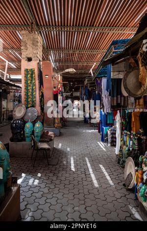 Straße in der Medina von Marrakesch mit einer Vielzahl kleiner Souvenirläden. Stockfoto