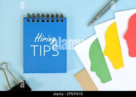 Einstellungstipps im Personalkonzept. Bürowohnung aus blauem Notizblock mit schriftlichem Text. Stockfoto