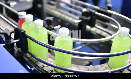 Transfer von Saftflaschen aus Kunststoff auf automatisierten Fördersystemen Industrieautomation für Verpackungen Stockfoto