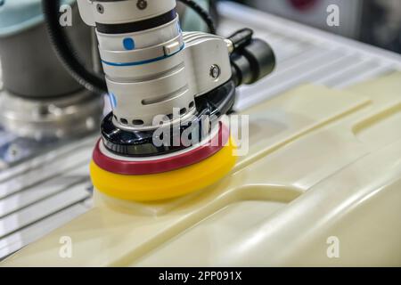 Roboterarm zum Polieren des Fahrzeugteils in der Produktionslinie. Stockfoto