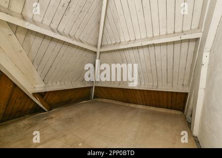 Ein unvollendeter Raum mit holzgetäfelten Wänden und weißer Farbe an den Wänden, es ist niemand drin Stockfoto