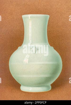 CH'IEN-LUNGEN GRAUE KRAKELVASE. VASE (Tsun), modelliert in Form eines alten Opferweingefäßes der Han-Dynastie, mit umschließenden Bändern, die in der Paste eine leichte Erleichterung darstellten, und drei massiven Griffen in Form von Schafsköpfen, die auf die Schulter projiziert wurden. Die Verglasung, mit der sie emailliert ist, ist in grauen Farbtönen gehalten, die durch ein enges Netz rötlich-brauner Linien durchbrochen sind. Auf der Schulter der Vase, wo die Glasur dicker ist, ist sie blassblau, und die knisternde Retikulation wird fast farblos; aus dem Buch „ ORIENTAL CERAMIC ART COLLECTION OF William Thompson Walters Stockfoto