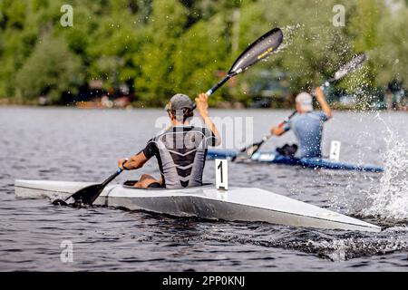 Zwei männliche Athleten Kajakfahrer auf einem Kajak-Kajak-Kajak-Championship-Rennen, Sportspiele im Sommer Stockfoto