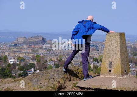 Edinburgh, Schottland, Großbritannien. 21. April 2023 Starke, bläuliche Winde auf dem Gipfel des Blackford Hill, bei denen die Besucher ihr Gleichgewicht im Wind nicht halten können. Blick über die Dächer der Stadt in Richtung Edinburgh Castle. Kredit: Craig Brown/Alamy Live News Stockfoto