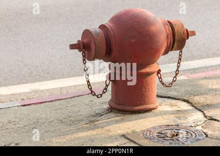 Der Feuerlöscher befindet sich auf dem Fußweg der Straße. Stockfoto