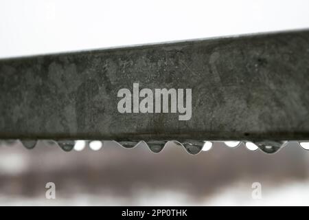 Blick auf Wassertropfen, die an einem Regentag an einem Metallgeländer hängen Stockfoto
