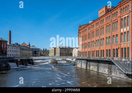 Die alte Industrielandschaft und der Fluss Motala im Frühling in Norrköping, Schweden. Stockfoto