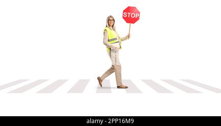 Gesamtbild einer jungen Frau, die an einer Fußgängerüberquerung läuft, mit einem Verkehrsschild isoliert auf weißem Hintergrund Stockfoto