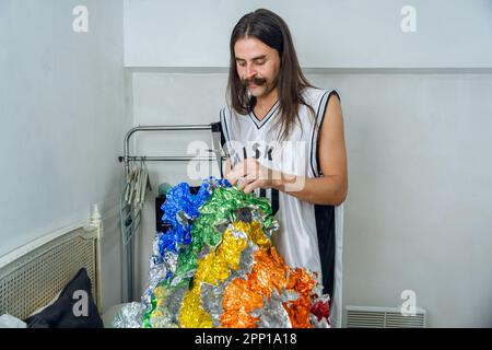 Geschlecht nicht binäre junge Latino-Person argentinischer ethnischer Herkunft, die still in ihrem Zimmer steht und ihr Drag-Queen-Outfit vorbereitet Stockfoto