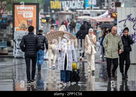 Während des starken Regens in Istanbul wurden Menschen mit Sonnenschirmen gesehen, um sich vor Regen im und um das Kadikoy-Dock zu schützen. Stockfoto