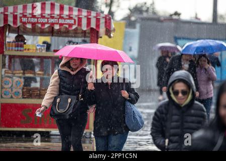 Während des starken Regens in Istanbul wurden Menschen mit Sonnenschirmen gesehen, um sich vor Regen im und um das Kadikoy-Dock zu schützen. Stockfoto
