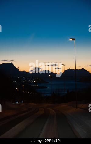Eine einzige Straßenbeleuchtung beleuchtet eine Straße in Mittelnorwegen am frühen Abend der langen norwegischen Winter. Stockfoto