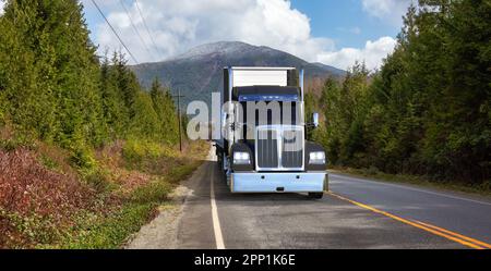 LKW-Fahrt auf der Scenic Road mit grünen Bäumen und Bergen im Hintergrund. Stockfoto