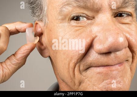 Eine Nahaufnahme eines Mannes, der ein Plastikgerät im Ohr trägt Stockfoto