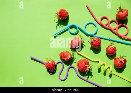 Kreatives Layout mit Erdbeersaft. Skizzieren Sie mit frischen Erdbeeren und Strohhalmen. Abstraktes Getränk. Draufsicht, flach liegend. Erdbeerentgiftungswasser. Obst Stockfoto