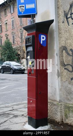 Rotes Metall-Parquimeter auf der Straße in Bologna, Italien Stockfoto