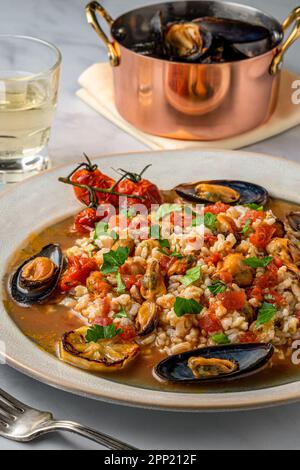 Miesmuscheln Risotto mit Knoblauch und Tomaten. Über Schuss. Stockfoto