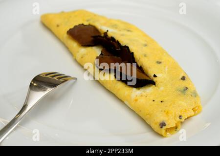 Französische Trüffel-Omelette-Eier oder Omelette-Auc-Trüffel mit schwarzen Sommertrüffeln auf einem weißen Teller Stockfoto