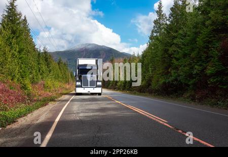 LKW-Fahrt auf der Scenic Road mit grünen Bäumen und Bergen im Hintergrund. Stockfoto