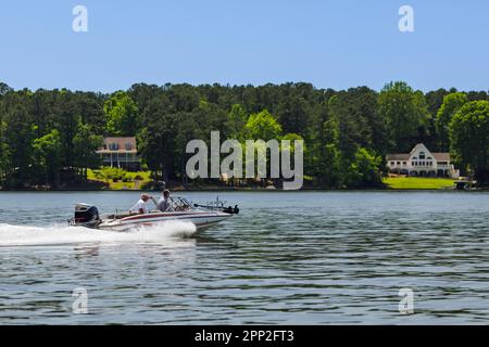 Bootsfahrer auf dem Fischerboot genießen den Sommertag auf dem See. Fahrt mit dem Motorboot auf dem Süßwassersee. Stockfoto