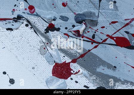 Makro-Nahaufnahme einer abstrakten schwarzen, grauen, weißen und roten Acryl- und Sprühfarbe auf Weiß. Spritzer, Tropfen, Flecken und Spray. Strukturierter Leinenhintergrund. Stockfoto