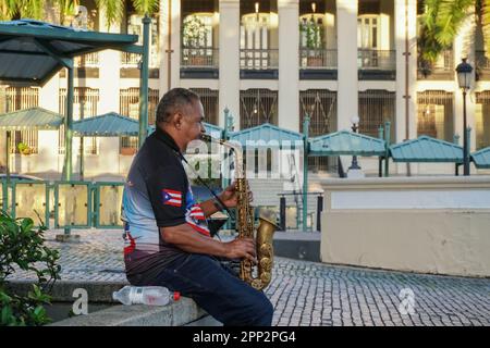 Emilio Vázquez spielt am 21. Oktober 2022 Saxophon auf dem Paseo de la Princesa in Old San Juan, Puerto Rico. Vázquez, der seit 40 Jahren in verschiedenen Gruppen spielt, sagt, dass es in den letzten drei Jahren weniger Auftritte gegeben hat. Jetzt nutzt er den Touristenverkehr aus, um die Musik der berühmten puertoricanischen Komponisten zu spielen. (Coraly Cruz Mejías/Global Press Journal) Stockfoto