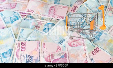 Das Konzept der Lebenshaltungskosten. Leerer Wagen auf einem Stapel türkischer Lira. Inflation steigt in der Türkei. Wirtschaftskrise. Steigende Kosten im täglichen Leben Stockfoto