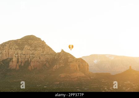 Sedona Arizona Heißluftballon steigt bei Sonnenaufgang für eine Gruppe von Touristen im Urlaub. Stockfoto