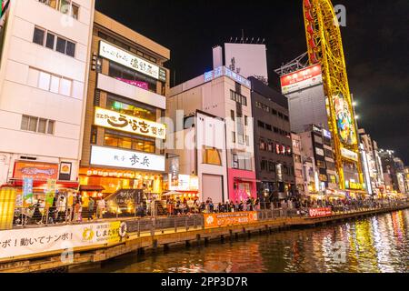 Osaka Japan 2023. April, Dotonbori River Kanal bei Nacht mit Neonlichtern und Menschenmassen treffen sich zum Abendessen und zur Unterhaltung, Straßenszene, Japan Stockfoto