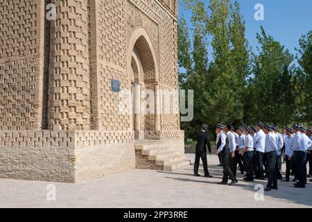 BUKHARA, USBEKISTAN - 09. SEPTEMBER 2022: Eine Gruppe usbekischer Studenten auf einem Ausflug am Eingang zum alten Mausoleum der Samaniden Stockfoto