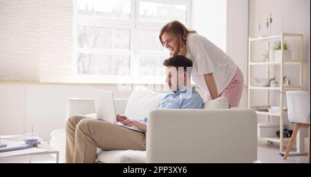 Familienpaar, Das Den Laptop Auf Dem Sofa Online Nutzt Stockfoto