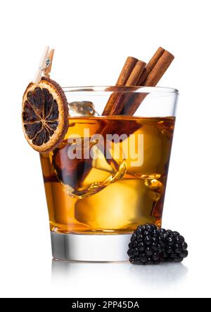 Altmodischer Whiskey-Cocktail mit trockenen Orangen, Zimt und Brombeeren und großen Eiswürfeln auf Weiß. Stockfoto