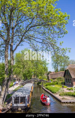 Boote, Holzbrücken und alte Häuser am Wasser in Giethoorn, Niederlande Stockfoto