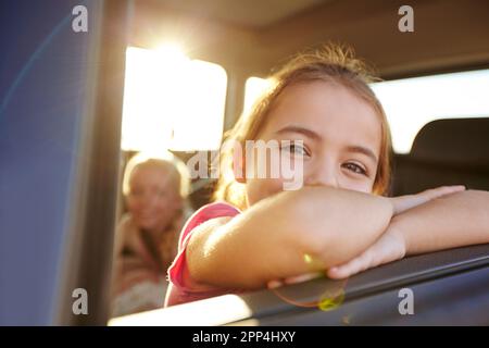 Es gibt eine ganze Welt da draußen. Ein kleines Mädchen, das im Auto unterwegs ist. Stockfoto