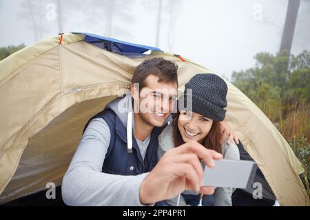 Camping-Selfies. Ein junges Paar, das während eines Campingausflugs ein Foto von sich macht. Stockfoto
