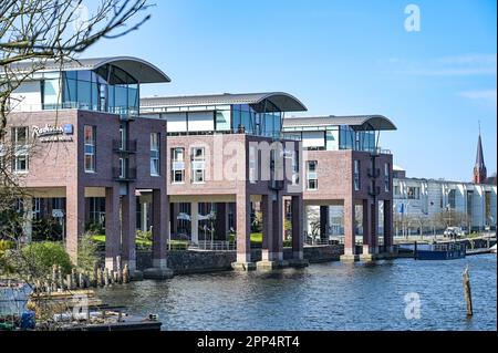 Lübeck, Deutschland, 17. April 2023: Gebäude des Radisson Blue Senator Hotels mit Fassdächern und Stelzen direkt am Ufer des Flusses Trave in Stockfoto