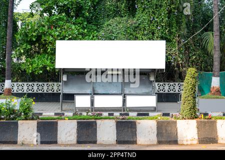 Ein leeres weißes Modell einer Bushaltestelle mit Plakatwand vor einem leeren Straßenhintergrund Stockfoto