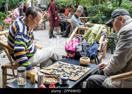 Zwei ältere Chinesen, die das Brettspiel spielen, gehen in ein Teehaus - China, Chengdu. Stockfoto