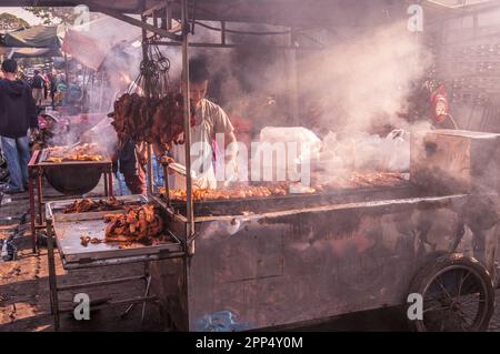 Kambodschanische Straßenverkäufer an einem Smokey BBQ Meat Street Stand während des chinesischen Neujahrs, Kandal Market, Phnom Penh, Kambodscha. © Kraig Stockfoto