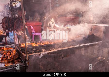 Kambodschanische Straßenverkäufer an einem Smokey BBQ Meat Street Stand während des chinesischen Neujahrs, Kandal Market, Phnom Penh, Kambodscha. © Kraig Stockfoto