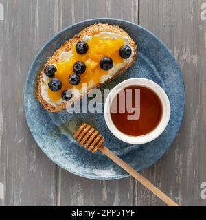 Flach Lay Brot mit Frischkäse Obst Teller mit Honig Stockfoto