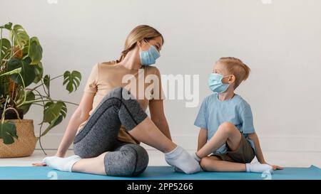 Full Shot Frau Kind trägt Gesichtsmasken Stockfoto