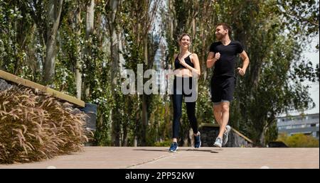 Vorderansicht Mann Frau joggt gemeinsam im Freien Stockfoto