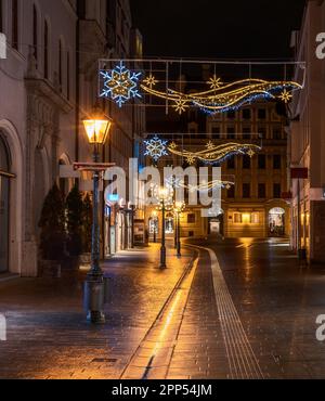 Straße in Augsbug bei Nacht mit Weihnachtsbeleuchtung dekoriert Stockfoto