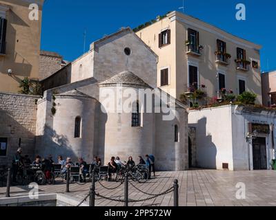 BARI, ITALIEN - 30. OKTOBER 2021: Restaurant in Bari, Italien, auf der Piazza del Ferrarese mit Kaffeetrinken vor der Kirche Chiesa della Vallisa Stockfoto
