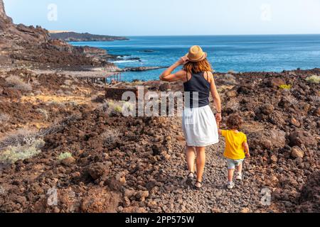 Mutter und Sohn gehen auf einem Pfad am Strand von Tacoron auf El Hierro, Kanarische Inseln Stockfoto